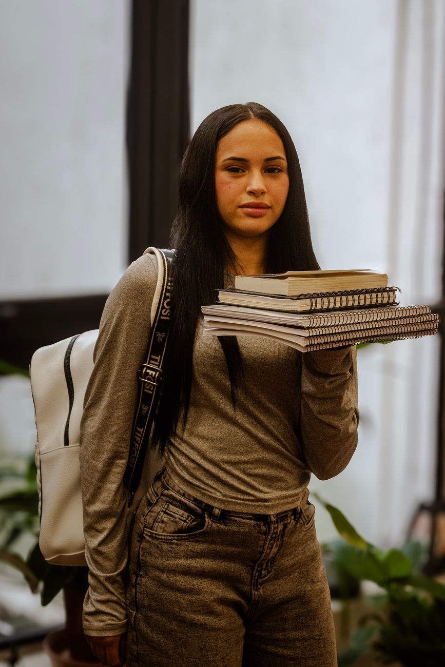 young student holding books indoors